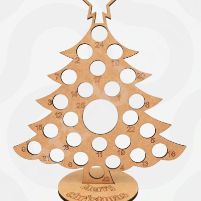 A large unfinished 6mm thick MDF Christmas tree advent calendar with 24 small holes for Lindt truffles and one large central hole for a Terry's Chocolate Orange, standing on a square base.