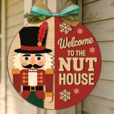 The Welcome to the Nut House Door Sign craft blank showing a finished 20cm circular MDF plaque with a painted 3D Nutcracker and festive red background.