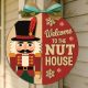 The Welcome to the Nut House Door Sign craft blank showing a finished 20cm circular MDF plaque with a painted 3D Nutcracker and festive red background.