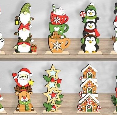 The Freestanding Festive Triple Stackers collection showing 10 painted MDF Christmas shelf sitters including stacked gnomes, snowmen, penguins, and gingerbread houses standing on a shelf.